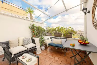 a patio with a couch and a table at San Pietro Nausicaa Penthouse in Rome