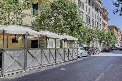 a row of umbrellas and cars parked on a street at San Giovanni Cozy Apt - Home and More in Rome