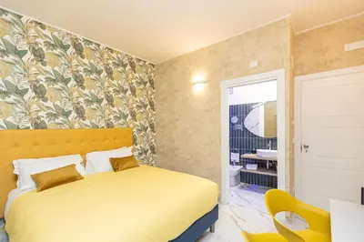 a bedroom with a yellow bed and a bathroom at Flowery Rainbow in Rome