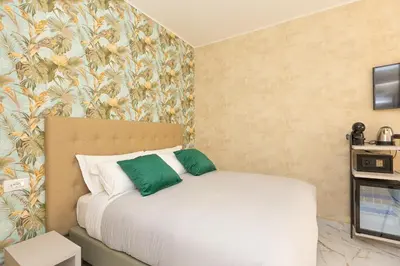 a bedroom with a bed with green and white pillows at Flowery Rainbow in Rome