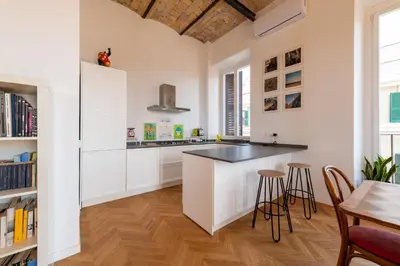 a kitchen with white cabinets and a table and chairs at Boho 202 in Rome