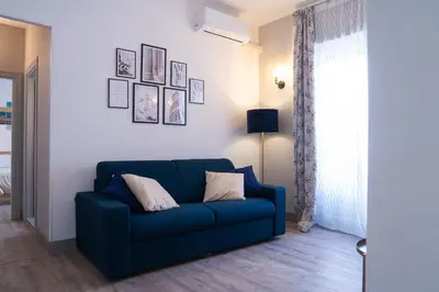 a blue couch in a living room with a window at Delia's Vatican House Near St Peter's in Rome