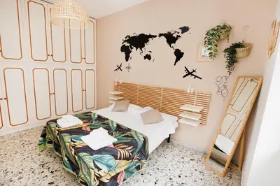a bedroom with a bed with a world map on the wall at RHOME SUITE VATICAN APTS in Rome