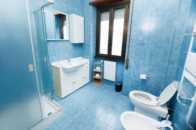 a blue bathroom with a toilet and a sink at RHOME SUITE VATICAN APTS in Rome