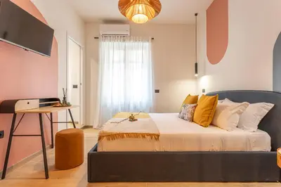 a bedroom with a bed and a desk and a television at YCH-Ambra Apartments a San Giovanni in Rome