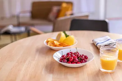 a table with two bowls of fruit and orange juice at YCH-Ambra Apartments a San Giovanni in Rome