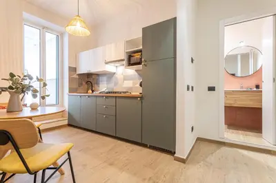 a kitchen with gray cabinets and a table and a chair at YCH-Ambra Apartments a San Giovanni in Rome