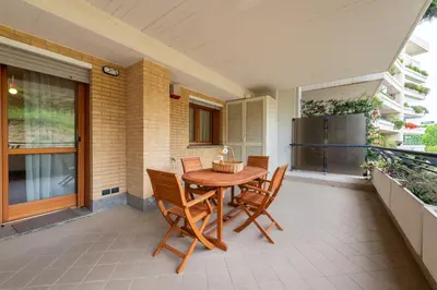 a patio with a wooden table and chairs on a balcony at Bonum Vitae in Rome