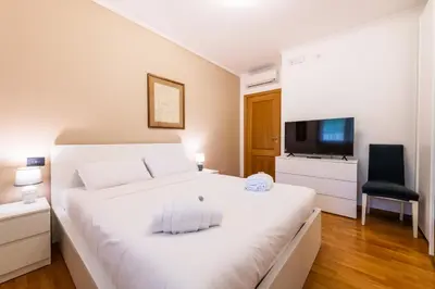 a bedroom with a white bed and a television at Bonum Vitae in Rome