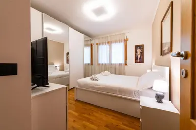 a white bedroom with a bed and a tv at Bonum Vitae in Rome