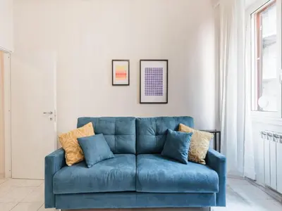 a blue couch sitting in a living room at The Best Rent - Spacious one-bedroom apartment near Colosseum in Rome