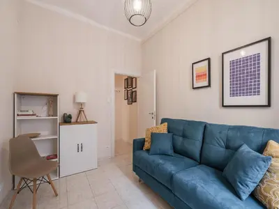 a living room with a blue couch and a table at The Best Rent - Spacious one-bedroom apartment near Colosseum in Rome