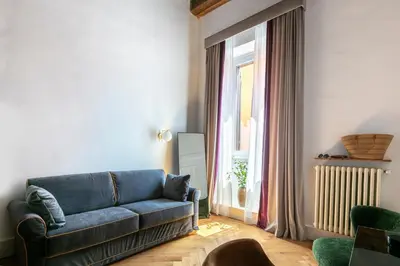 a living room with a blue couch and a window at Residenza Il Vicolo by Hili in Rome