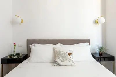 a bedroom with a white bed with white pillows at Residenza Il Vicolo by Hili in Rome