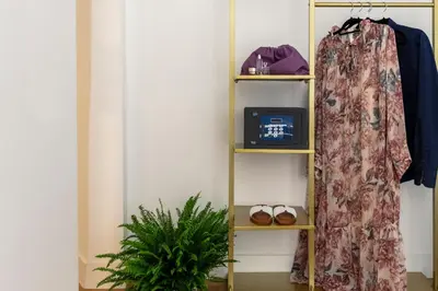 a room with a shelf with a robe and a plant at Residenza Il Vicolo by Hili in Rome