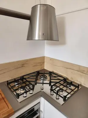 a kitchen stove top with a silver hood at Appartamento Loft ex mulini in Rome