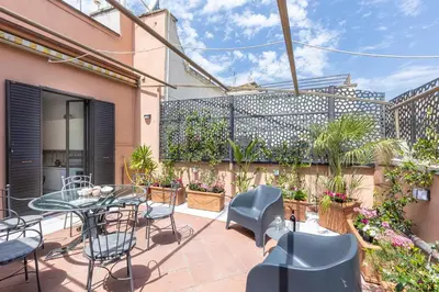a patio with a table and chairs and a building at Tre Lune Penthouse by Rental in Roma in Rome