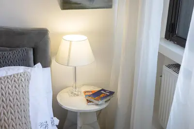 a lamp on a table next to a bed at Tre Lune Penthouse by Rental in Roma in Rome