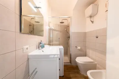 a white bathroom with a sink and a toilet at Archetto by the Vatican in Rome