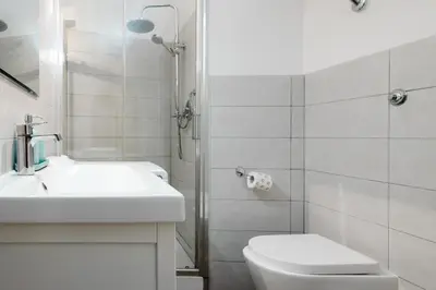 a white bathroom with a sink and a toilet at Archetto by the Vatican in Rome