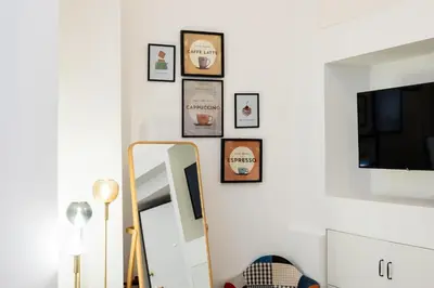 a mirror and some framed pictures on a wall at Archetto by the Vatican in Rome