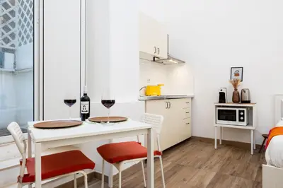 a small kitchen with a table and two glasses of wine at Archetto by the Vatican in Rome