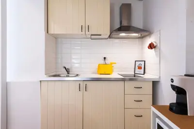 a kitchen with white cabinets and a sink at Archetto by the Vatican in Rome