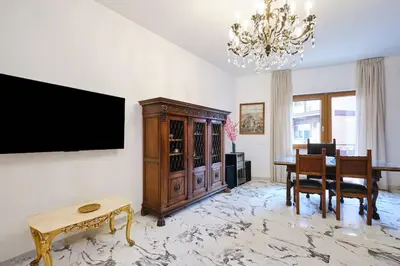 a living room with a television and a dining room at Monteverde - Vaticano - Esperienza Romana 1BDR by Hôtea in Rome