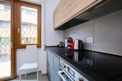 a kitchen with a black counter top and a window at Monteverde - Vaticano - Esperienza Romana 1BDR by Hôtea in Rome
