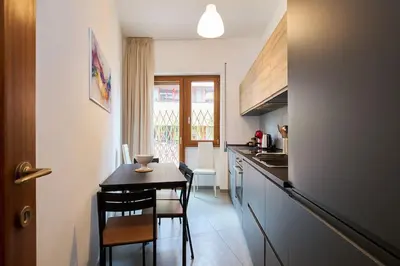 a kitchen with a table and chairs and a dining room at Monteverde - Vaticano - Esperienza Romana 1BDR by Hôtea in Rome
