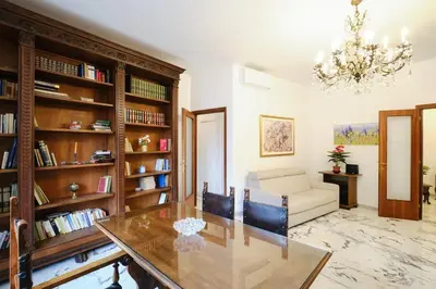 a living room with a table and a chandelier at Monteverde - Vaticano - Esperienza Romana 1BDR by Hôtea in Rome