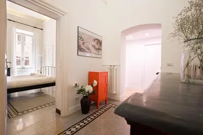 a living room with a bed and a vase of flowers at Quirino Visconti Apartment Prati in Rome
