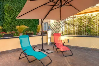 two chairs and an umbrella on a patio at Conca D'Oro Terrace in Rome