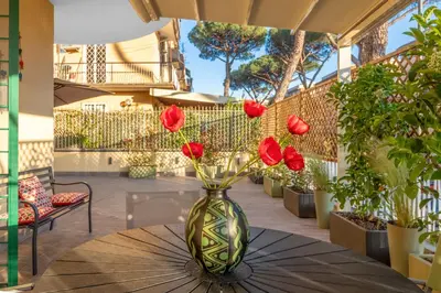 a vase with red flowers sitting on a table at Conca D'Oro Terrace in Rome