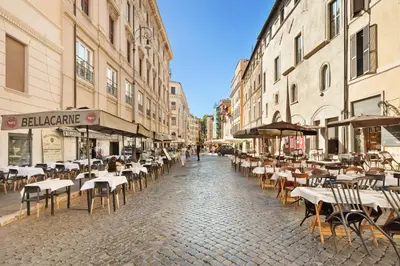 an empty street with tables and chairs and buildings at Campitelli 9 - Loft in Ancient Rome in Rome