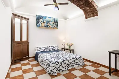 a bedroom with a bed and a ceiling fan at Campitelli 9 - Loft in Ancient Rome in Rome