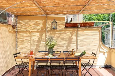 a patio with a wooden table and chairs at iFlat Trastevere Stylish 4 Bedroom Penthouse in Rome