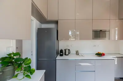 a kitchen with white cabinets and a refrigerator at iFlat Trastevere Stylish 4 Bedroom Penthouse in Rome