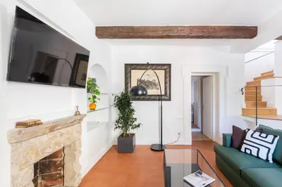 a living room with a fireplace and a tv at iFlat Trastevere Stylish 4 Bedroom Penthouse in Rome