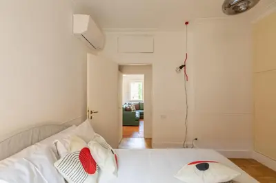 a bedroom with a white bed with pillows on it at iFlat Trastevere Stylish 4 Bedroom Penthouse in Rome