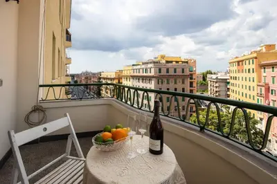 a bottle of wine and a bowl of fruit on a balcony at Ninkasi Bed and Beer San Giovanni Via La Spezia 74 Roma in Rome