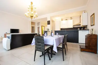 a dining room with a table and chairs and a kitchen at Ninkasi Bed and Beer San Giovanni Via La Spezia 74 Roma in Rome