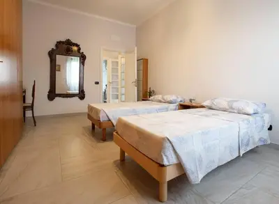a bedroom with two beds and a mirror at Ninkasi Bed and Beer San Giovanni Via La Spezia 74 Roma in Rome