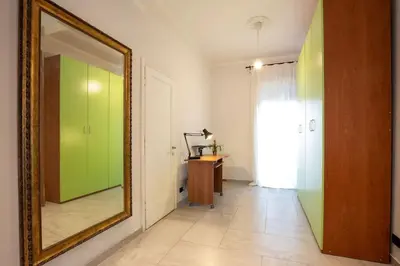 a mirror on a wall in a hallway with a table at Ninkasi Bed and Beer San Giovanni Via La Spezia 74 Roma in Rome