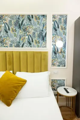 a bedroom with a white bed and a yellow pillow at Domus Laurina - Maison D'Art Collection in Rome