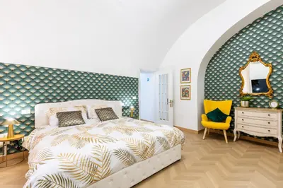 a bedroom with a bed and a yellow chair at Colosseum Boutique apartment in Rome