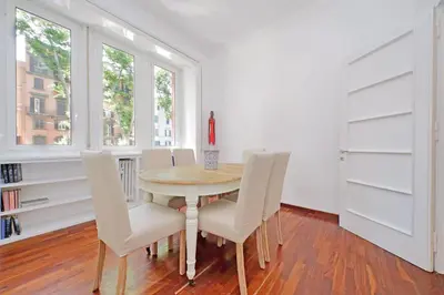 a dining room with a table and white chairs at Charme e Style: Splendid Apartment with 2 Bedrooms in Rome
