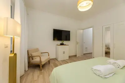 a white bedroom with a bed and a chair at Cozy Apartment Monteverde near Trastevere in Rome