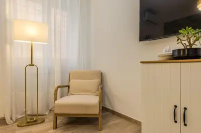 a chair sitting next to a floor lamp in a room at Cozy Apartment Monteverde near Trastevere in Rome