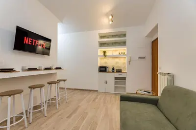 a living room with a couch and some bar stools at Cozy Apartment Monteverde near Trastevere in Rome
